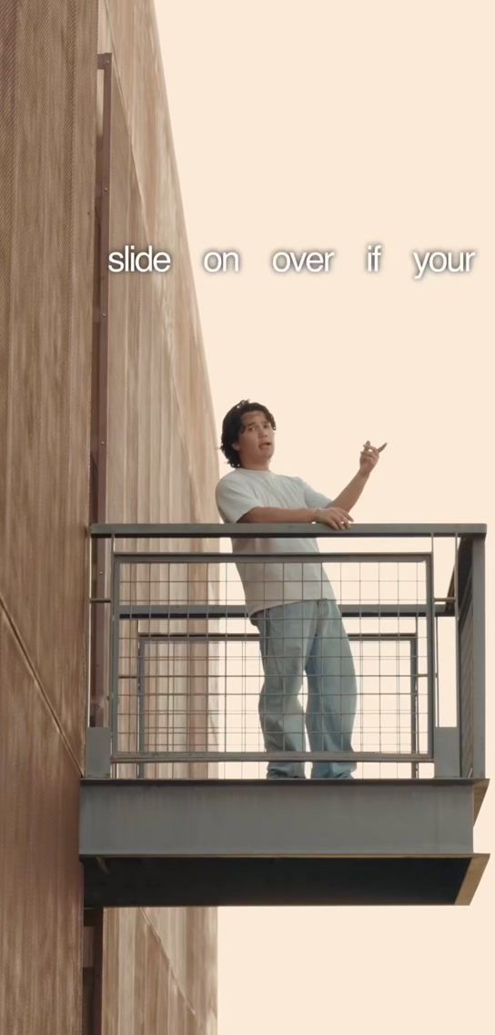 STVN standing on a small balcony against a cream wall